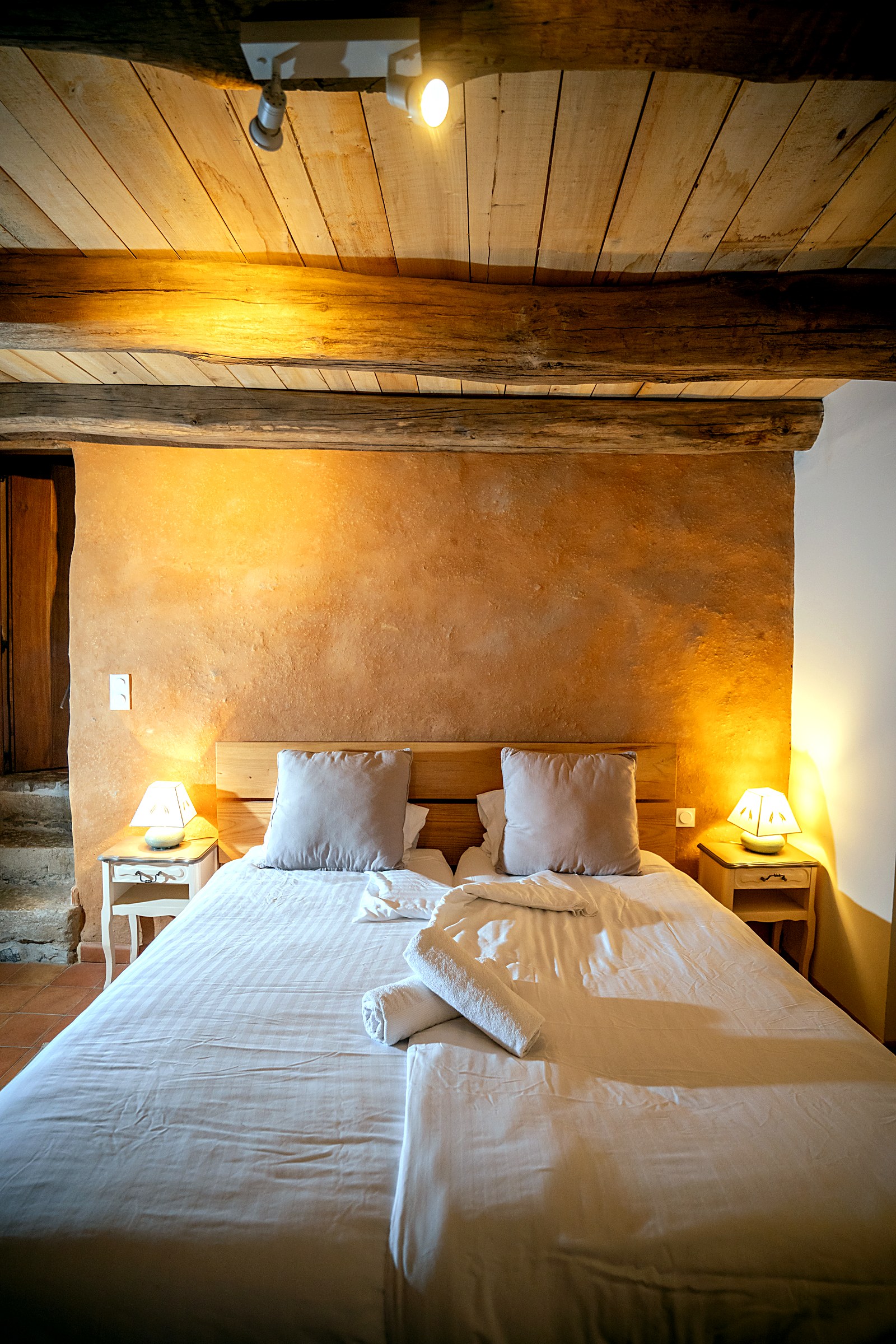 Chambre spacieuse aux murs ocres, gîte L'Oustal du Larzac